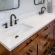 White qaurtz bathroom countertops on double vanity with matte black hardware and wood cabinets.
