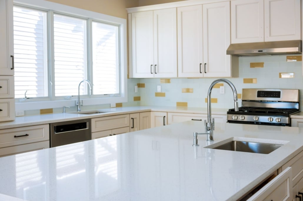 Bright white kitchen with white quartz countertops.