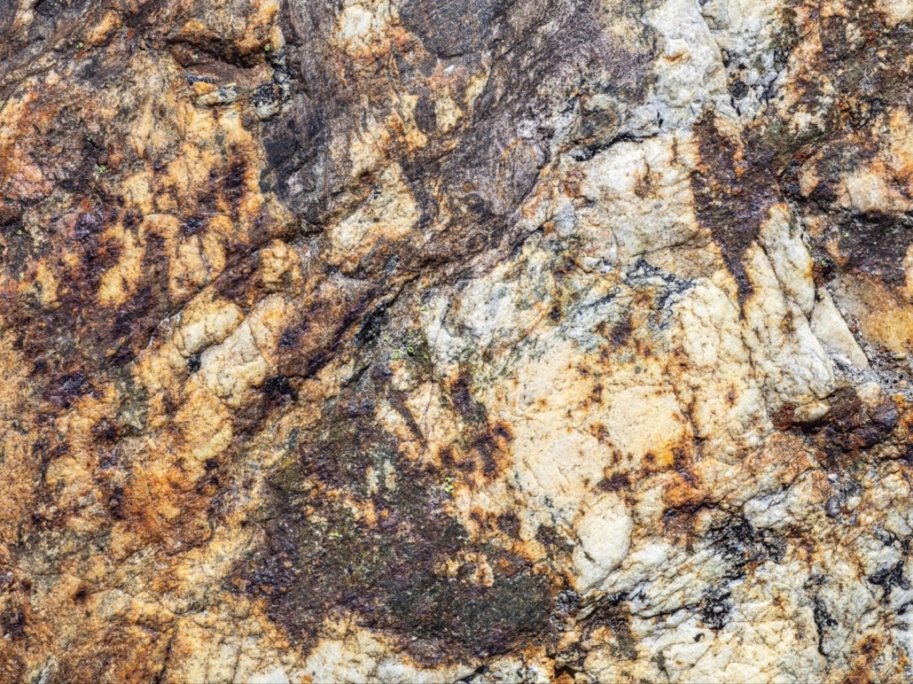 Close-up of natural granite stone texture with brown, cream, and gray veining.