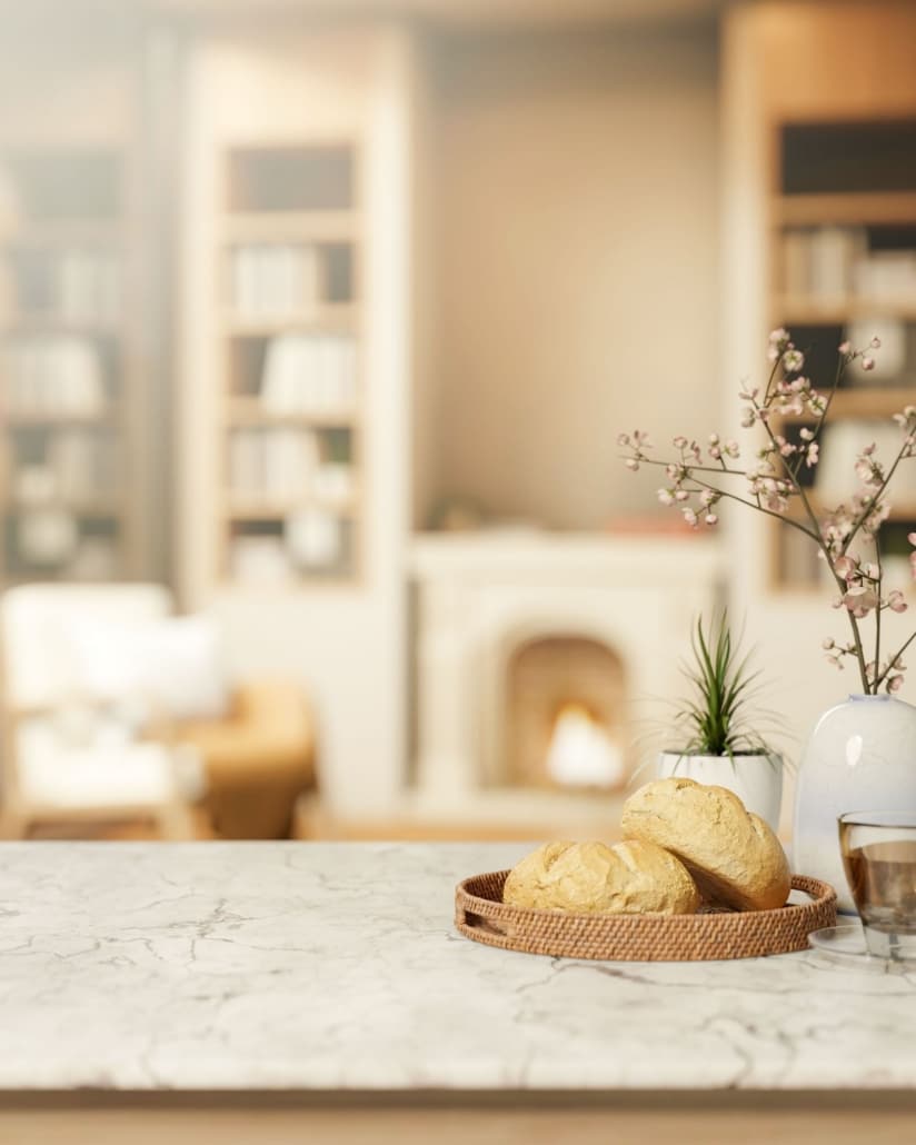 Fresh baked sourdough bread on quartzite countertops in a warmly lit kitchen.